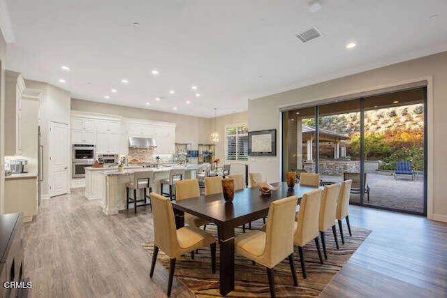 dining space featuring light wood-type flooring, recessed lighting, and baseboards