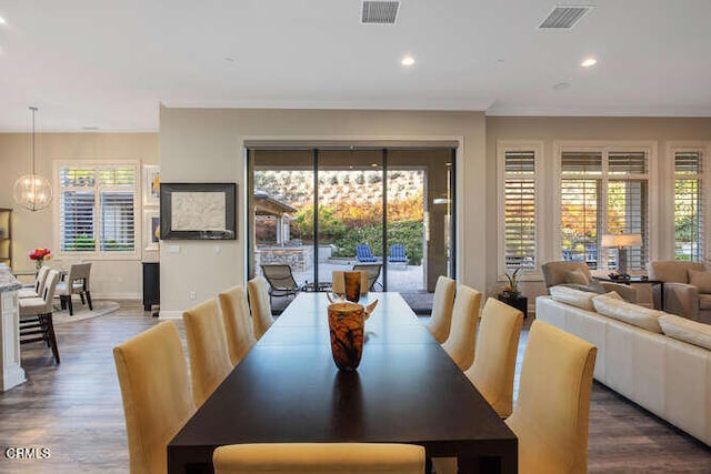 dining room featuring a chandelier, dark wood finished floors, plenty of natural light, ornamental molding, and recessed lighting