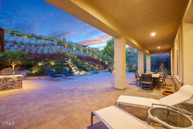 patio terrace at dusk featuring outdoor dining area
