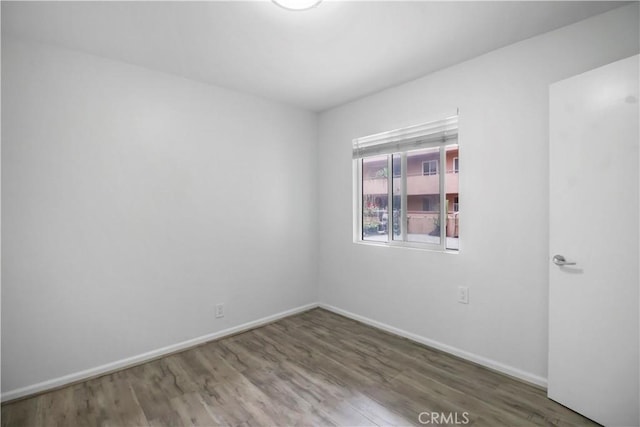 unfurnished room featuring wood finished floors and baseboards