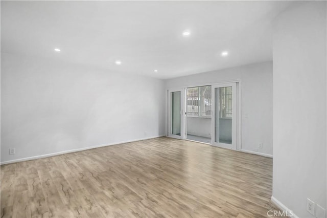 spare room featuring wood finished floors, recessed lighting, and baseboards