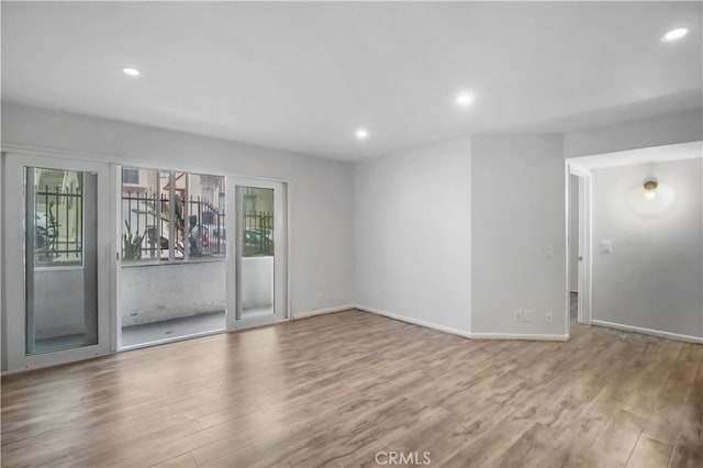 unfurnished living room featuring light wood finished floors, recessed lighting, and baseboards
