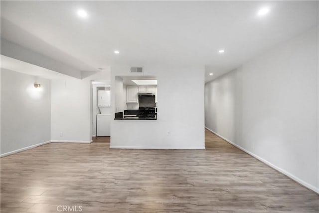 unfurnished living room featuring light wood-style flooring, recessed lighting, and baseboards