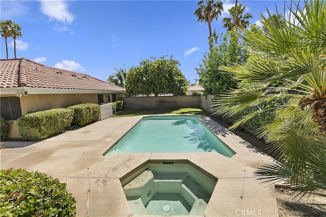 view of swimming pool with an in-ground hot tub and a fenced backyard