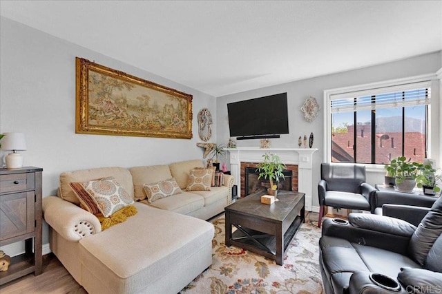 living room with light wood-type flooring, a brick fireplace, and baseboards
