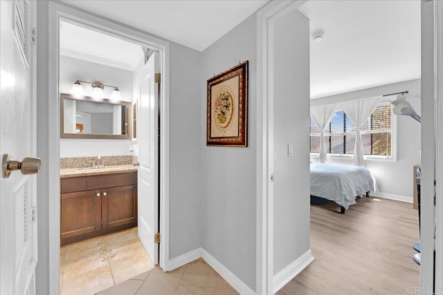 hallway featuring a sink and baseboards