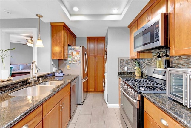 2916 Alanwood Ct, Spring Valley, CA 91978 - kitchen with stainless steel appliances, a raised ceiling, ceiling fan, brown cabinetry, and dark stone countertops