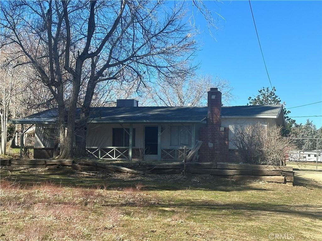 rear view of house featuring a porch and a chimney