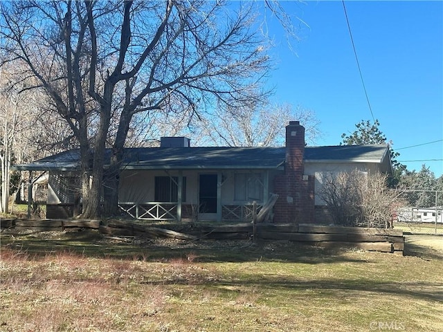 rear view of house featuring a porch and a chimney
