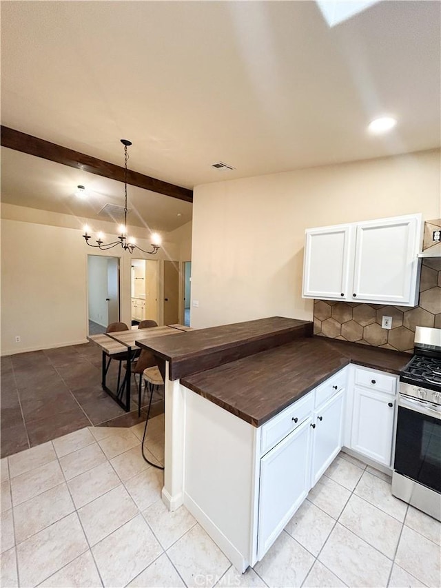 770 Cypress Ln, Blythe, CA 92225 - kitchen featuring stainless steel gas range oven, tasteful backsplash, light tile patterned floors, white cabinets, and a chandelier