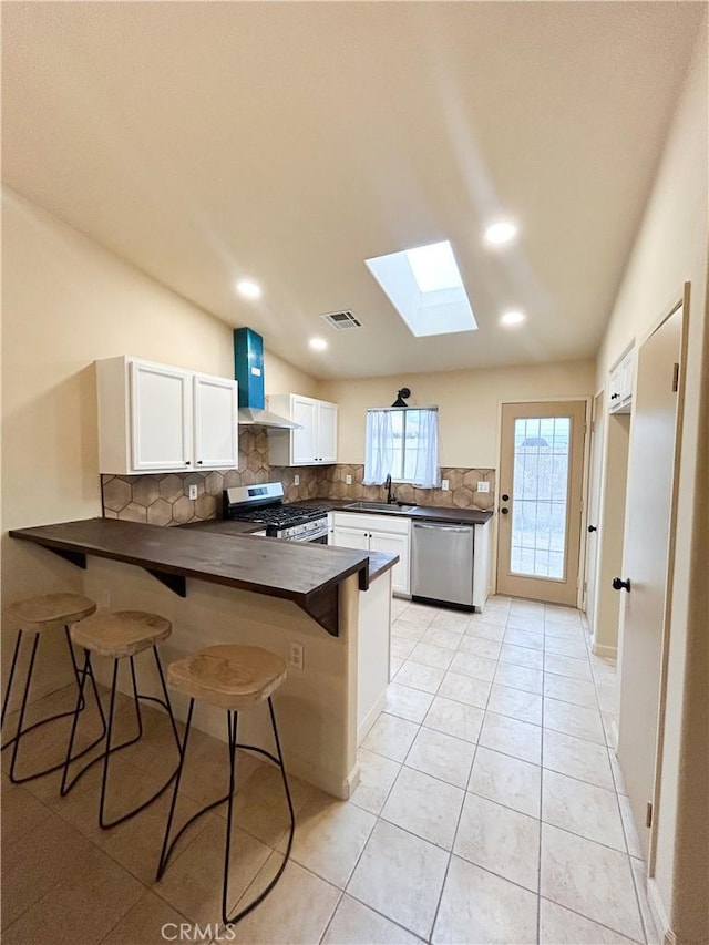 770 Cypress Ln, Blythe, CA 92225 - kitchen featuring appliances with stainless steel finishes, a peninsula, a skylight, dark countertops, and a sink