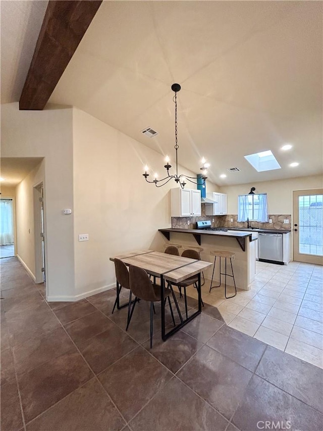 770 Cypress Ln, Blythe, CA 92225 - dining area featuring a chandelier, vaulted ceiling, tile patterned flooring, a skylight, and baseboards