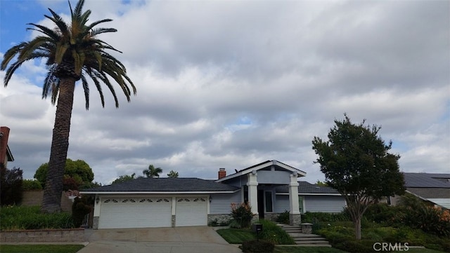 view of front of property with concrete driveway, stone siding, and a garage