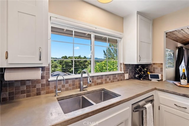 kitchen featuring a sink, white cabinets, and light countertops