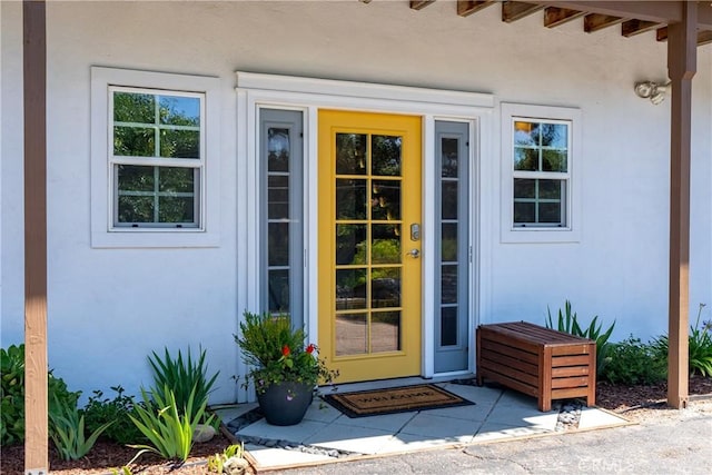 property entrance with stucco siding