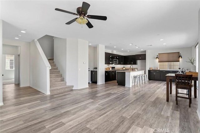 22069 Windham Way, Saugus, CA 91350 - living area featuring light wood-style flooring, recessed lighting, a ceiling fan, and stairway