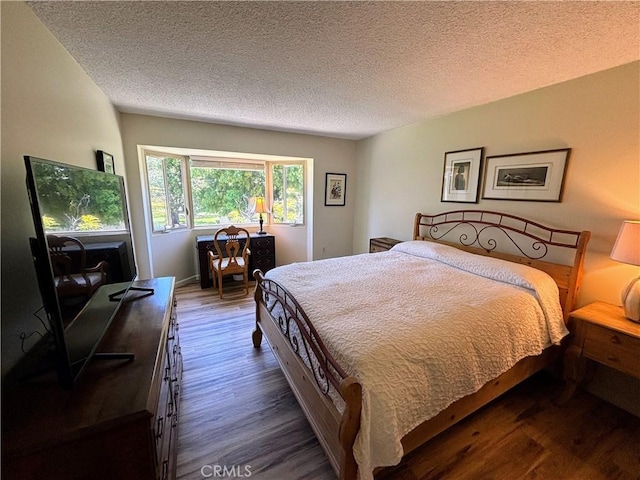 bedroom featuring dark wood finished floors and a textured ceiling