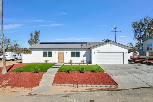 16938 Bell Ave, Lake Elsinore, CA 92530 - ranch-style home with concrete driveway, an attached garage, roof mounted solar panels, stucco siding, and roof with shingles