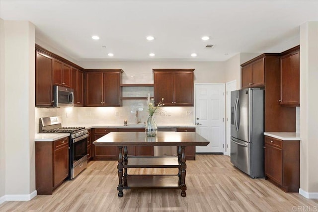 1514 Crown Ln Unit 1, Chula Vista, CA 91915 - kitchen featuring appliances with stainless steel finishes, open shelves, light wood finished floors, decorative backsplash, and light countertops