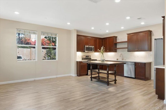 1514 Crown Ln Unit 1, Chula Vista, CA 91915 - kitchen featuring appliances with stainless steel finishes, open shelves, light wood-style flooring, decorative backsplash, and recessed lighting