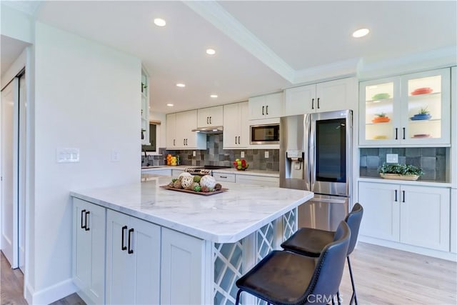 3364 Punta Alta Unit 1E, Laguna Woods, CA 92637 - kitchen with appliances with stainless steel finishes, white cabinets, backsplash, light wood-style flooring, and recessed lighting