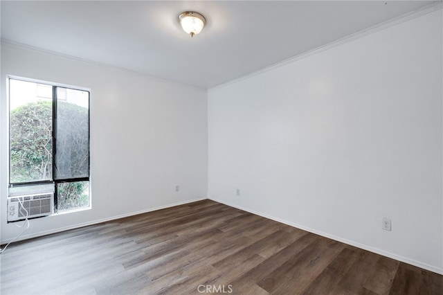 empty room with ornamental molding, wood finished floors, baseboards, and cooling unit