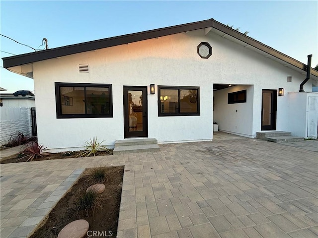 17037 Covello St, Van Nuys, CA 91406 - rear view of house with stucco siding, a patio area, and entry steps