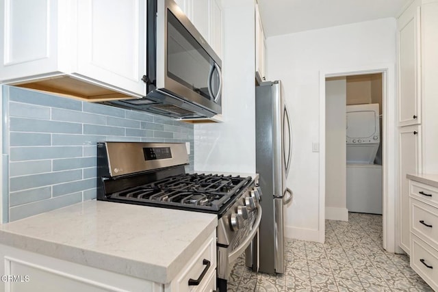 1540 Whitefield Rd, Pasadena, CA 91104 - kitchen with appliances with stainless steel finishes, stacked washer / drying machine, white cabinets, and backsplash