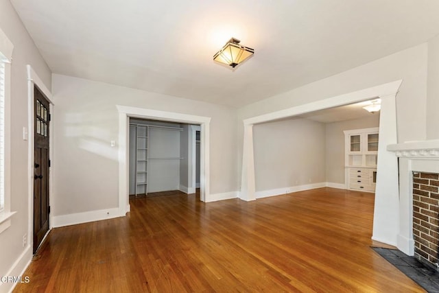 1540 Whitefield Rd, Pasadena, CA 91104 - unfurnished living room with a brick fireplace, wood finished floors, and baseboards