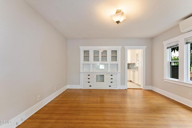 1540 Whitefield Rd, Pasadena, CA 91104 - empty room featuring light wood-style flooring, baseboards, and an AC wall unit