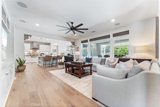 living area with ceiling fan, light wood-style flooring, and recessed lighting
