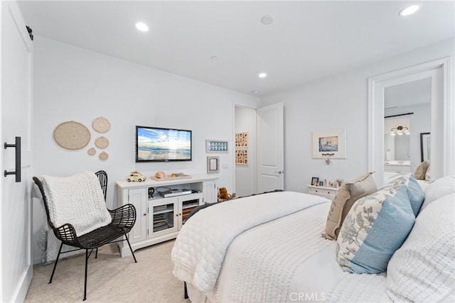 bedroom featuring light colored carpet, recessed lighting, baseboards, and connected bathroom