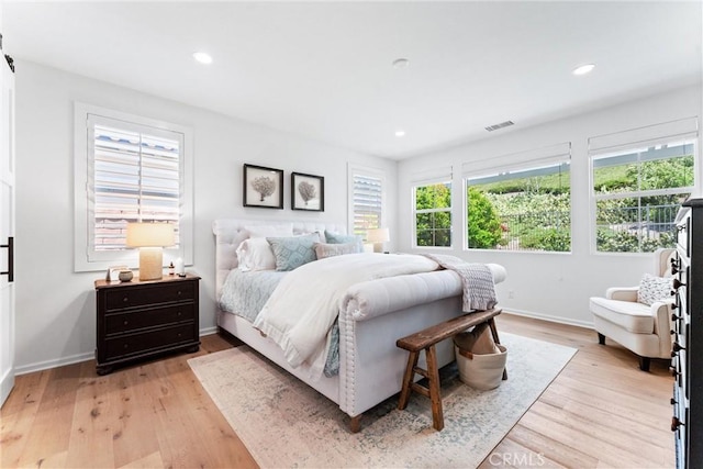 bedroom featuring multiple windows, light wood-style flooring, recessed lighting, and baseboards