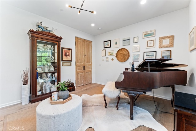 sitting room featuring wood finished floors, baseboards, a chandelier, and recessed lighting