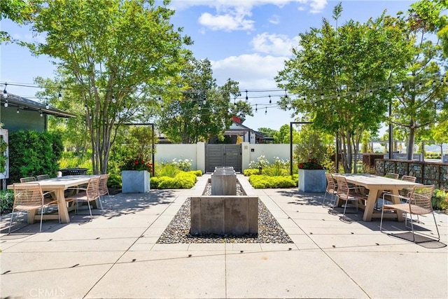 view of patio / terrace featuring outdoor dining space, fence, and a gate