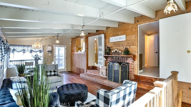 living room with plenty of natural light, beam ceiling, wood finished floors, wood walls, and a chandelier