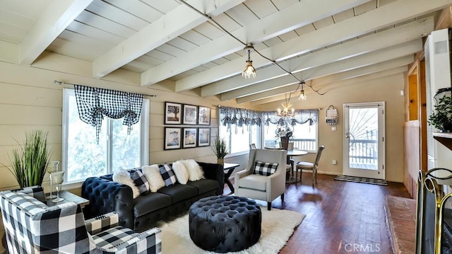 living area with dark wood-style floors, a chandelier, and beamed ceiling