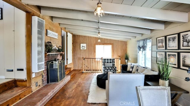 living room with a heating unit, wood finished floors, beam ceiling, and wooden walls