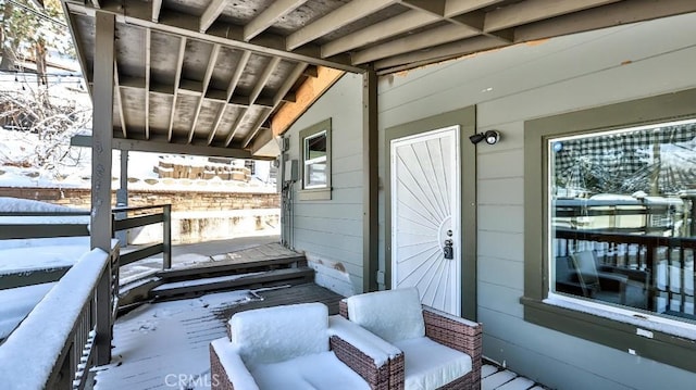 snow covered deck featuring a porch