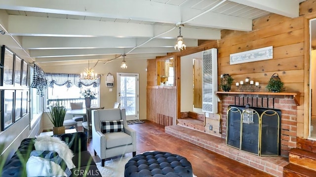 living room featuring wood finished floors, a chandelier, wooden walls, a heating unit, and a brick fireplace