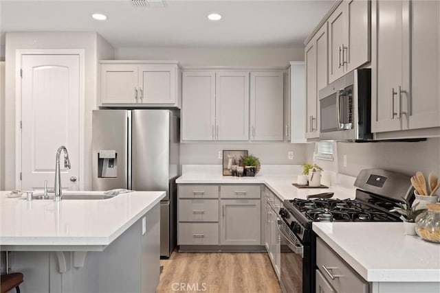 3445 Chamberlain Run, Chico, CA 95973 - kitchen with stainless steel appliances, a sink, light wood finished floors, light countertops, and gray cabinets
