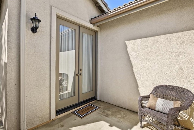 doorway to property featuring french doors and stucco siding