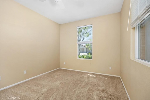 empty room with ceiling fan, carpet flooring, and baseboards