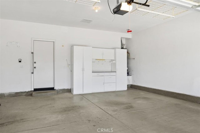 garage featuring a garage door opener and baseboards