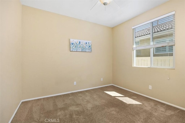spare room featuring carpet, baseboards, and a ceiling fan