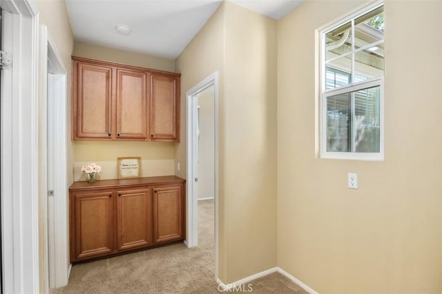 hallway with light carpet and baseboards