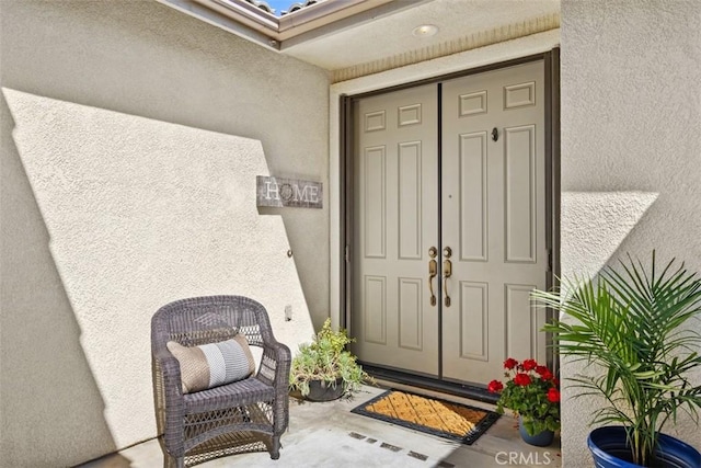 view of exterior entry with stucco siding