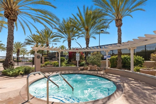 view of swimming pool featuring a community hot tub, fence, and a pergola