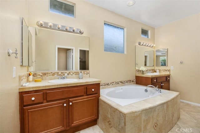 bathroom featuring a garden tub, two vanities, and backsplash