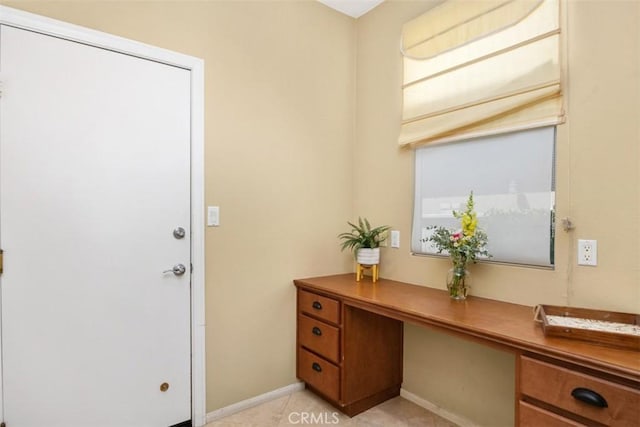 home office featuring baseboards and built in desk